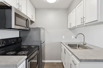 White kitchen with gray countertops and appliances